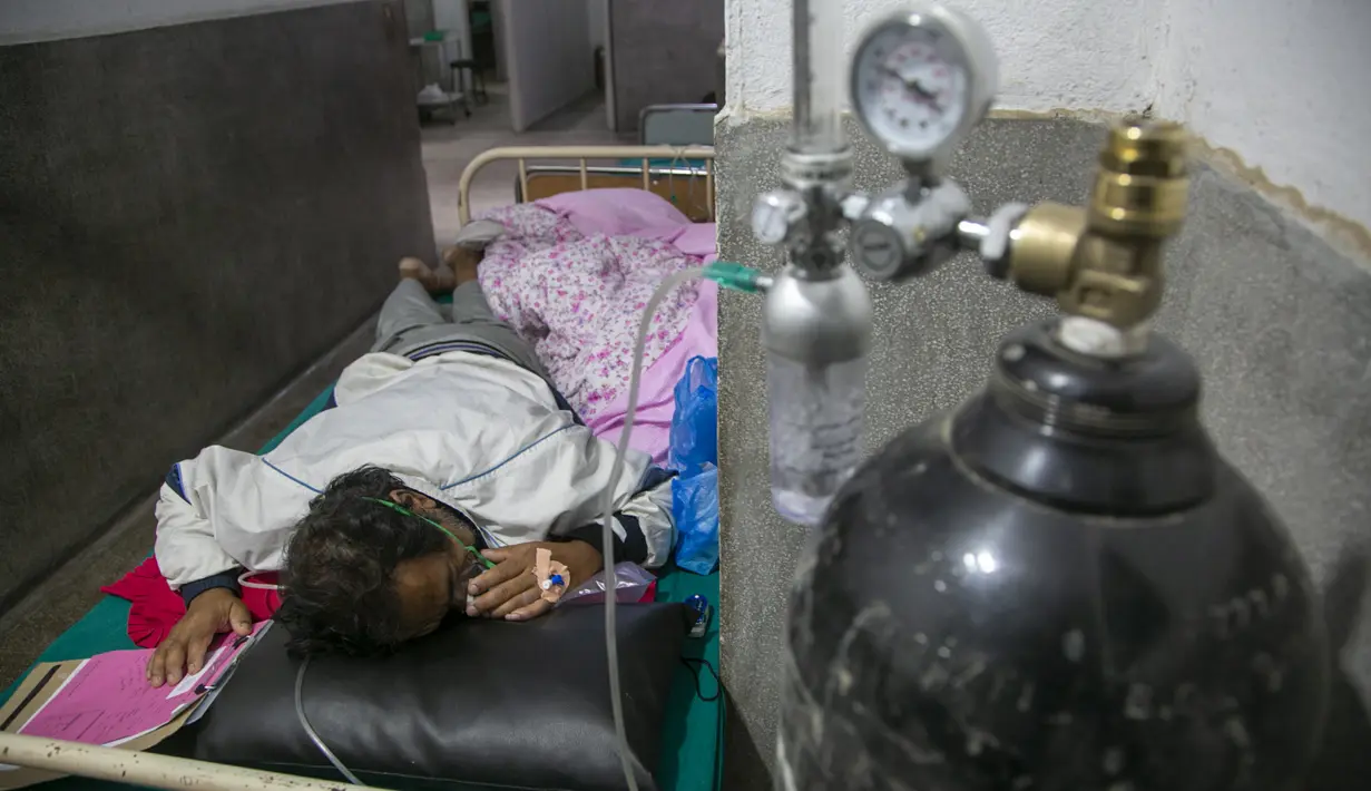 Seorang pasien COVID-19 menerima oksigen di koridor bangsal gawat darurat rumah sakit di Kathmandu, Rabu (5/5/2021). Lockdown di ibu kota Kathmandu dan distrik sekitarnya diperpanjang ketika negara Himalaya mencatat infeksi harian COVID-19 dan kematian tertinggi. (AP Photo/Niranjan Shrestha)