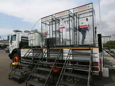 Warga menyemprotkan diri menggunakan cairan antiseptik di bilik disinfektan chamber di CheCk Point PSBB, perbatasan Jakarta - Tangerang Selatan, Pasar Jumat, Kamis (16/4/2020). Disinfektan chamber diperuntukkan bagi masyarakat sekitar selama Corona COVID-19. (Liputan6.com/Fery Pradolo)