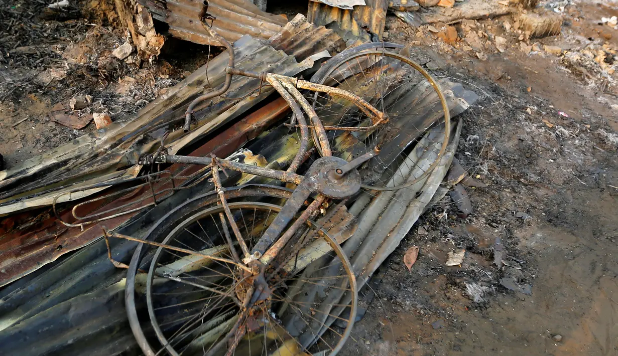 Rangka sebuah sepeda di antara puing-puing setelah kebakaran sebuah kamp bagi pengungsi Muslim Rohingya di negara bagian Rakhine, Myanmar, Selasa (3/5). Kebakaran menghancurkan 50 hunian sementara dalam kamp bagi pengungsi asing. (REUTERS/Soe Zeya Tun)