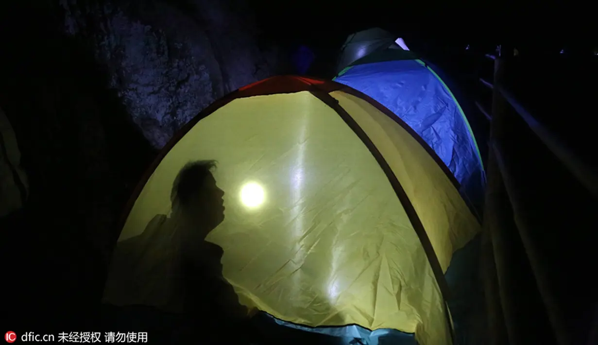 Peserta saat berada di dalam tenda saat berkemah bersama di tebing Gunung Laojun, Louyang, Henan, China (16/7). Lebih dari 100 backpacker kamping bersama di tebing pada ketinggian 1.700 mdpl selama 2 hari satu malam. (Chinadaily/photo/IC)