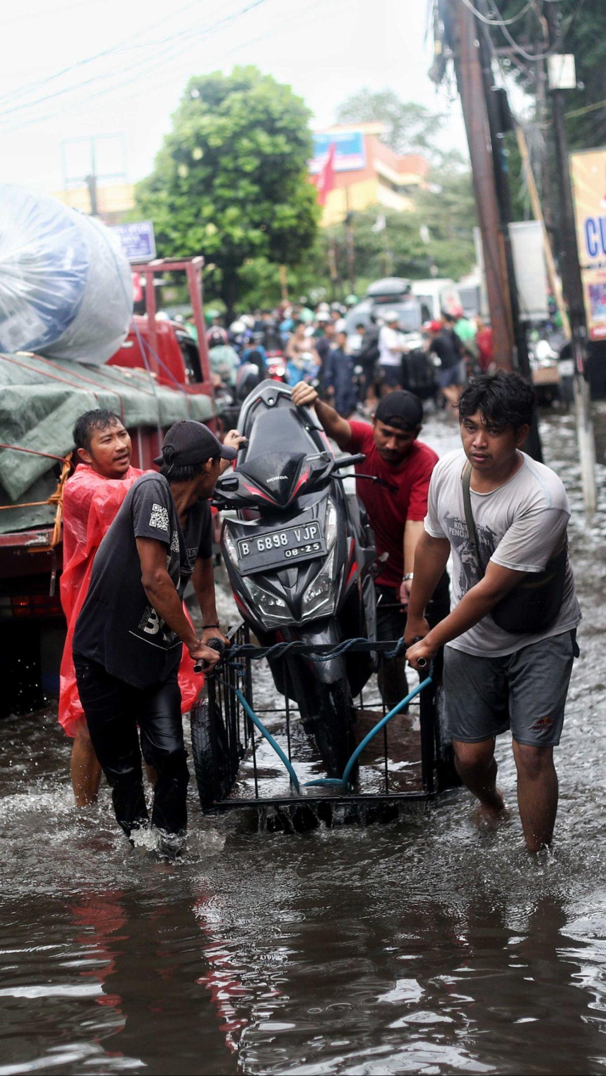 Banjir yang cukup tinggi membuat jalanan tersebut tak bisa dilalui beberapa kendaraan, utamanya sepeda motor.&nbsp;Liputan6.com/Angga Yuniar