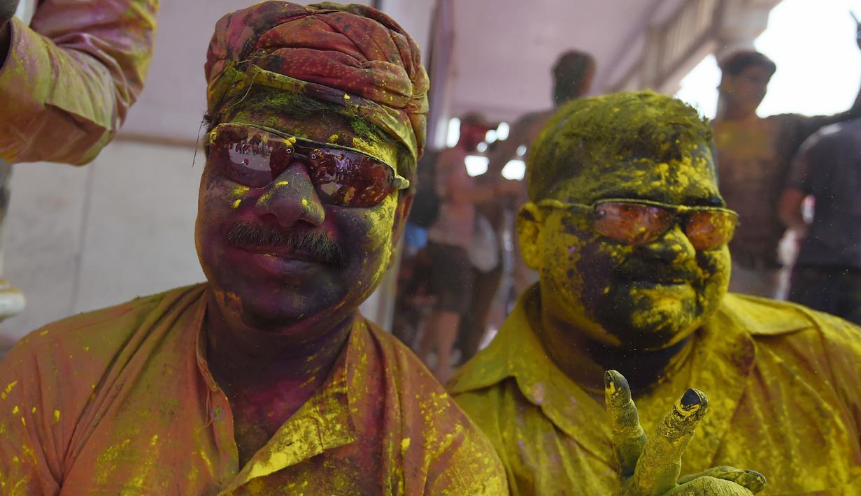 Umat Hindu merayakan Holi, festival warna musim semi, di sebuah kuil di desa Nandgaon, negara bagian Uttar Pradesh, 5 Maret 2020. Ribuan orang India menyambut musim semi pada Kamis (5/3) dengan merayakan Festival Holi yang identik dengan aksi saling melemparkan bubuk warna warni. (Money SHARMA/AFP)