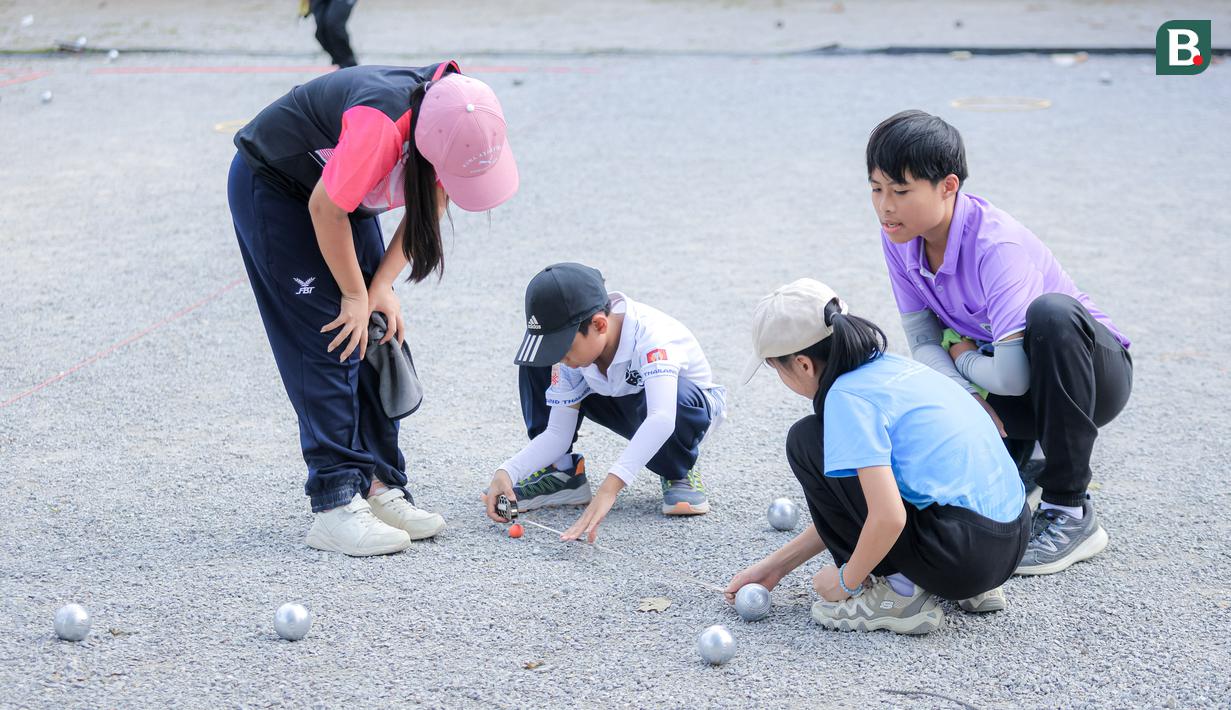 Anak-anak sedang mengukur hasil lemparannya saat bermain olahraga Petanque di Lapangan Latih Dua Kompleks 700th Anniversary of Chiang Mai Stadium, Kamis (11/12/2025).