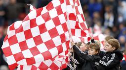 Suporter cilik Stoke City mengibarkan bendera klub sebelum pertandingan antara Stoke City vs Manchester City di Stadion Britania, Sabtu (5/12/2015). (Reuters/Carl Recine)