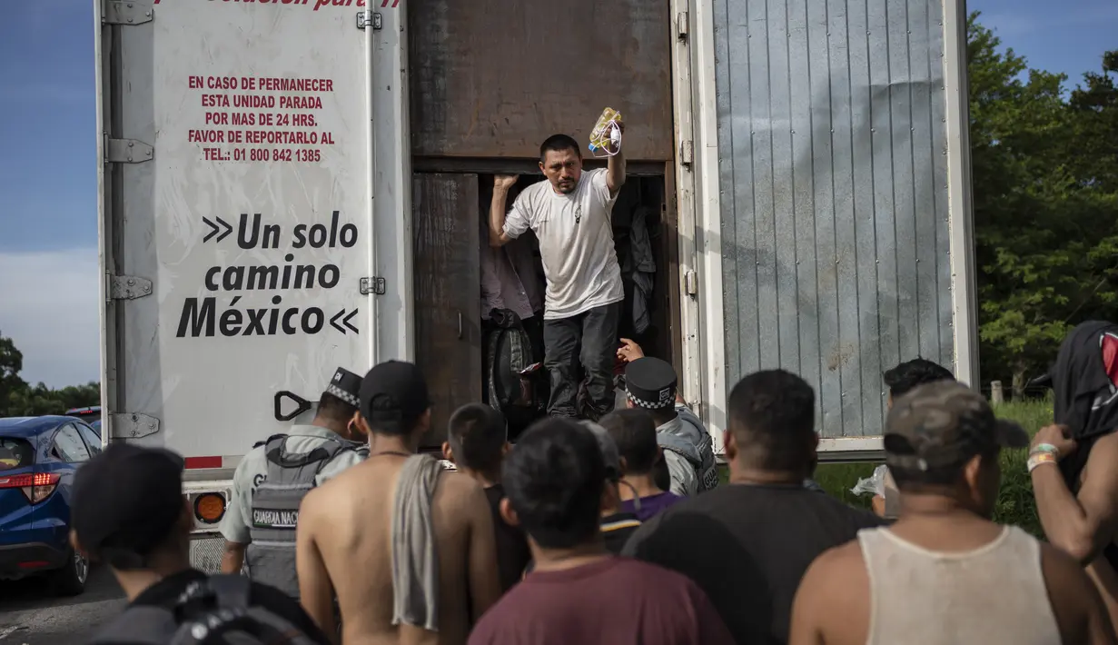 Migran mengambil barang-barang mereka setelah ditahan oleh otoritas imigrasi di Veracruz, Meksiko, Minggu, 23 Juli 2023. (AP Photo/Felix Marquez)