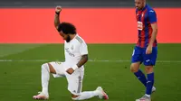 Bek Real Madrid, Marcelo, menyumbangkan satu gol saat timnya menang 3-1 atas Eibar, Minggu (15/6/2020). Selepas mencetak gol, Marcelo berlutut sebagai bentuk penghormatan kepada mendiang George Floyd. (AFP/PIERRE-PHILIPPE MARCOU)