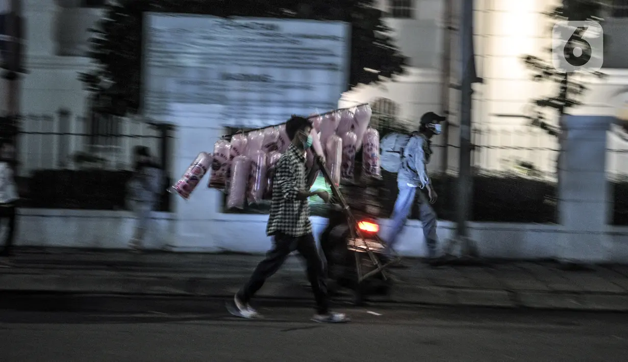 Pedagang menbawa dagangannya di kawasan Kota Tua, Jakarta, Kamis (31/12/2020). Pemprov DKI Jakarta menutup kawasan Kota Tua pada malam Tahun Baru kali ini guna mencegah kerumunan warga sebagai langkah memutus penyebaran COVID-19. (merdeka.com/Iqbal S. Nugroho)