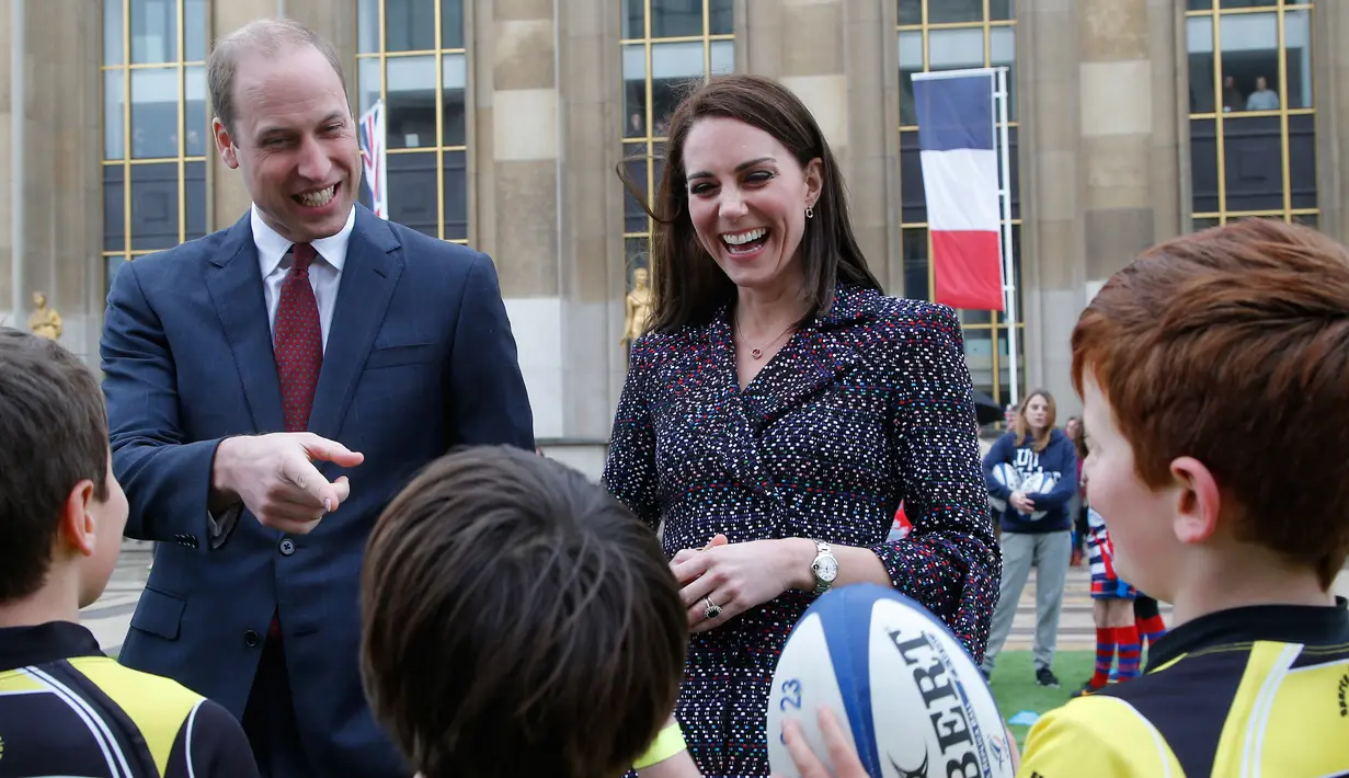 Pangeran William dan Kate Middleton menyapa pemain cilik rugby di Trocadero square, Paris, 18 Maret 2017. William dan Kate mengadakan tur kenegaraan, di tengah rumor perselingkuhan pangeran Inggris itu dengan model Australia. (AP Photo/Michel Euler, Pool)