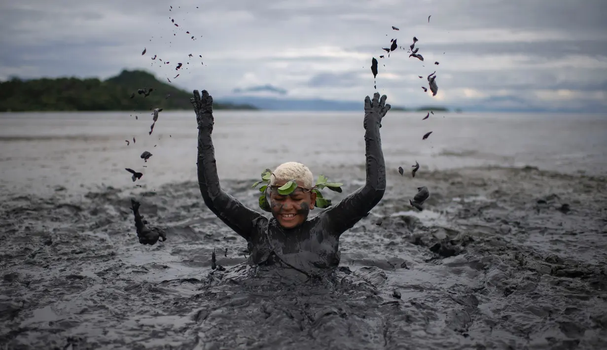 Seorang wanita bermain lumpur selama mengikuti "Bloco da Lama", pesta mandi lumpur di Paraty, negara bagian Rio de Janeiro, Brasil (2/3). "Bloco da Lama" diketahui sudah ada sejak 1986 lalu. (AFP Photo/Mauro Pimentel)