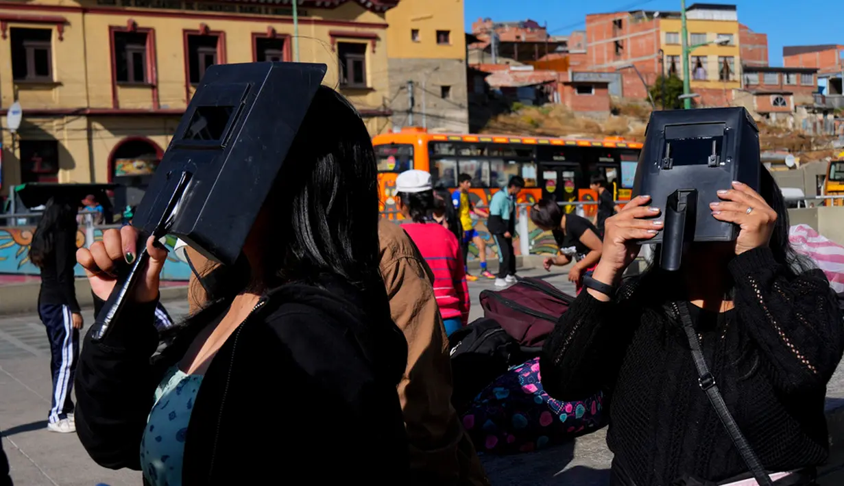 Masyarakat menyaksikan Gerhana Matahari Cincin Api di La Paz, Bolivia, Sabtu (14/10/2023). Jalur Gerhana Matahari Cincin Api melewati Amerika Serikat bagian barat, Meksiko, Amerika Tengah, dan sebagian Amerika Selatan. (AP Photo/Juan Karita)