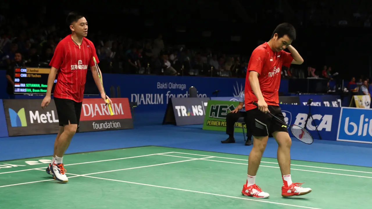Ganda Putra Hendra Setiawan/Boon Heong Taan tertunduk saat laga melwan Li Junhui/Liu  Yuchen (Tiongkok) di babak 16 besar Indonsia Open 2017 di JCC Plenary Hall, Jakarta, Kamis (15/6).  Hendra/Boon kalah 15-21, 15-21. (Liputan6.com/Helmi Fithriansyah)