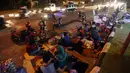 Pemudik menyempatkan beristirahat di pinggir jalan Kota Cirebon karena kelelahan berkendara dari Jakarta, Jumat (24/6). Mereka beristirahat sambil mendinginkan kendaraan bermotor. (Liputan6/JohanTallo)