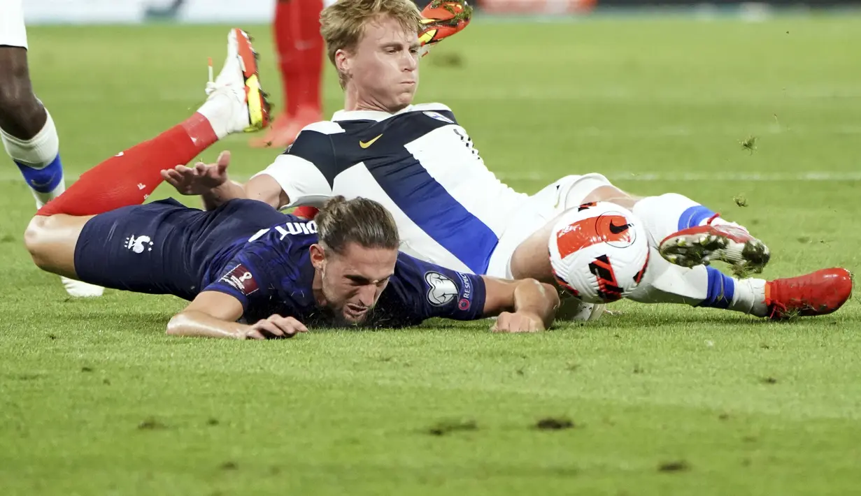 Gelandang Prancis, Adrien Rabiot berebut bola dengan pemain Finlandia, Rasmus Schuller pada pertandingan kualifikasi grup D Piala Dunia 2022 di stadion Decines di Lyon, Prancis, Rabu (8/9/2021). Prancis menang atas Finlandia 2-0. (AP Photo/Laurent Cirpiani)