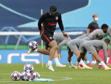 Pelatih Atletico Madrid Diego Simone bermain dengan bola sementara para pemain melakukan peregangan saat sesi latihan di Stadion Jose Alvalade, Lisbon, Portugal, Rabu (12/8/2020). Atletico Madrid akan menghadapi Leipzig pada perempat final Liga Champions. (Miguel A. Lopes/Pool via AP)