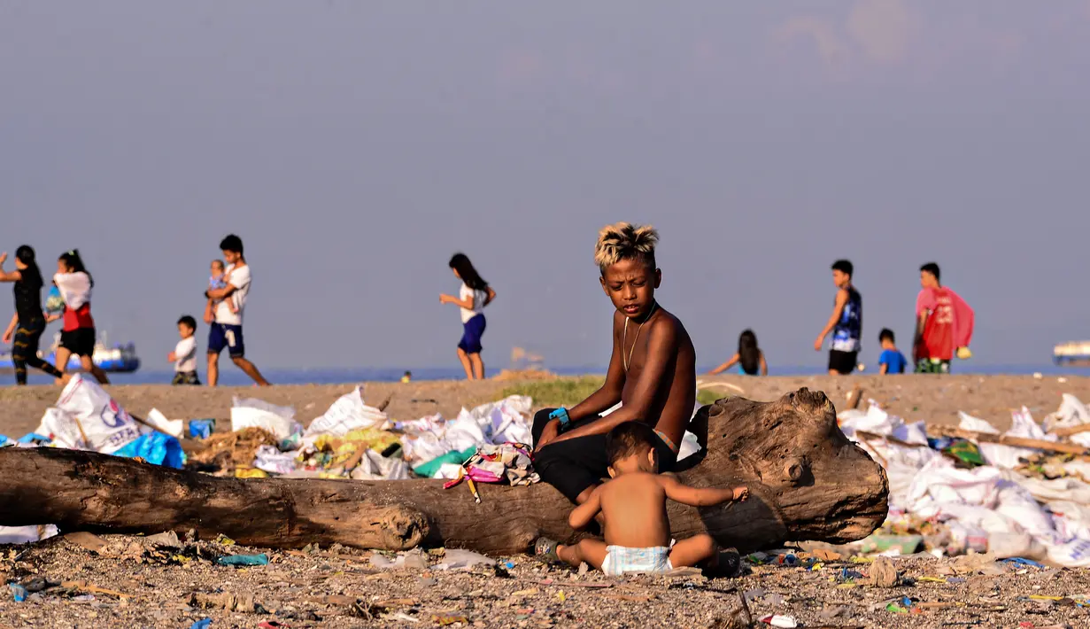 Anak-anak menyortir sampah di permukiman kumuh di sepanjang garis Pantai Baseco di Manila, Filipina (28/9/2019). Daerah memiliki pantai yang sering dikunjungi beberapa warga Manila meskipun tingkat coliform berbahaya di perairan yang berdekatan. (AFP Photo/Maria Tan)