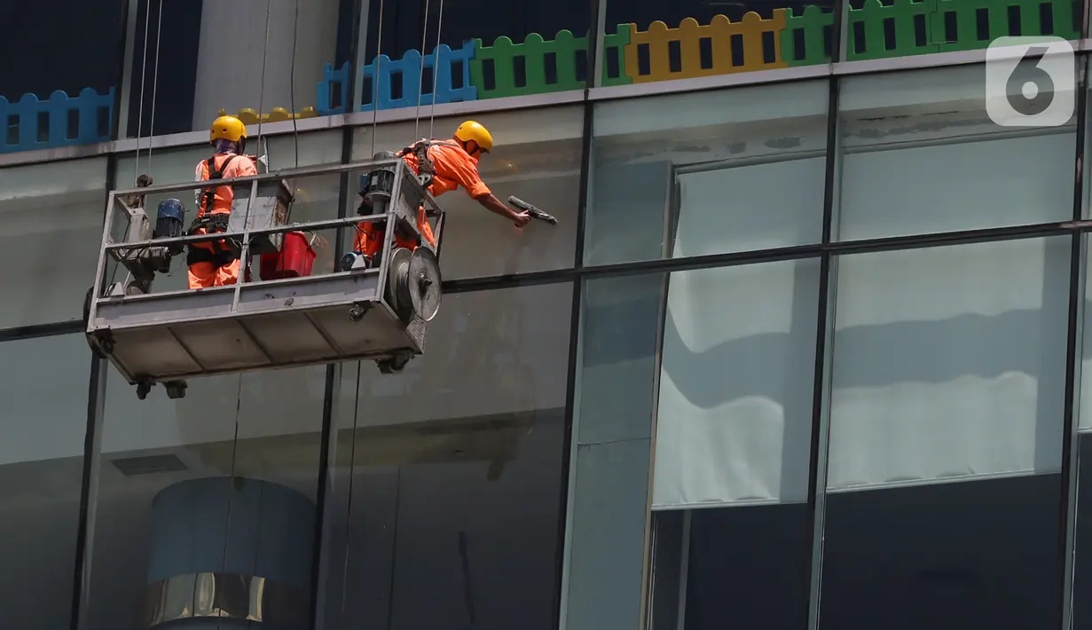 Pekerja membersihkan kaca gedung bertingkat di kawasan Jakarta, Kamis (2/4/2020). Dari 128 juta angkatan kerja di Indonesia, hanya 39% atau 50 jutaan pekerja yang terlindungi jaminan sosial ketenagakerjaan. (Liputan6.com/Herman Zakharia)