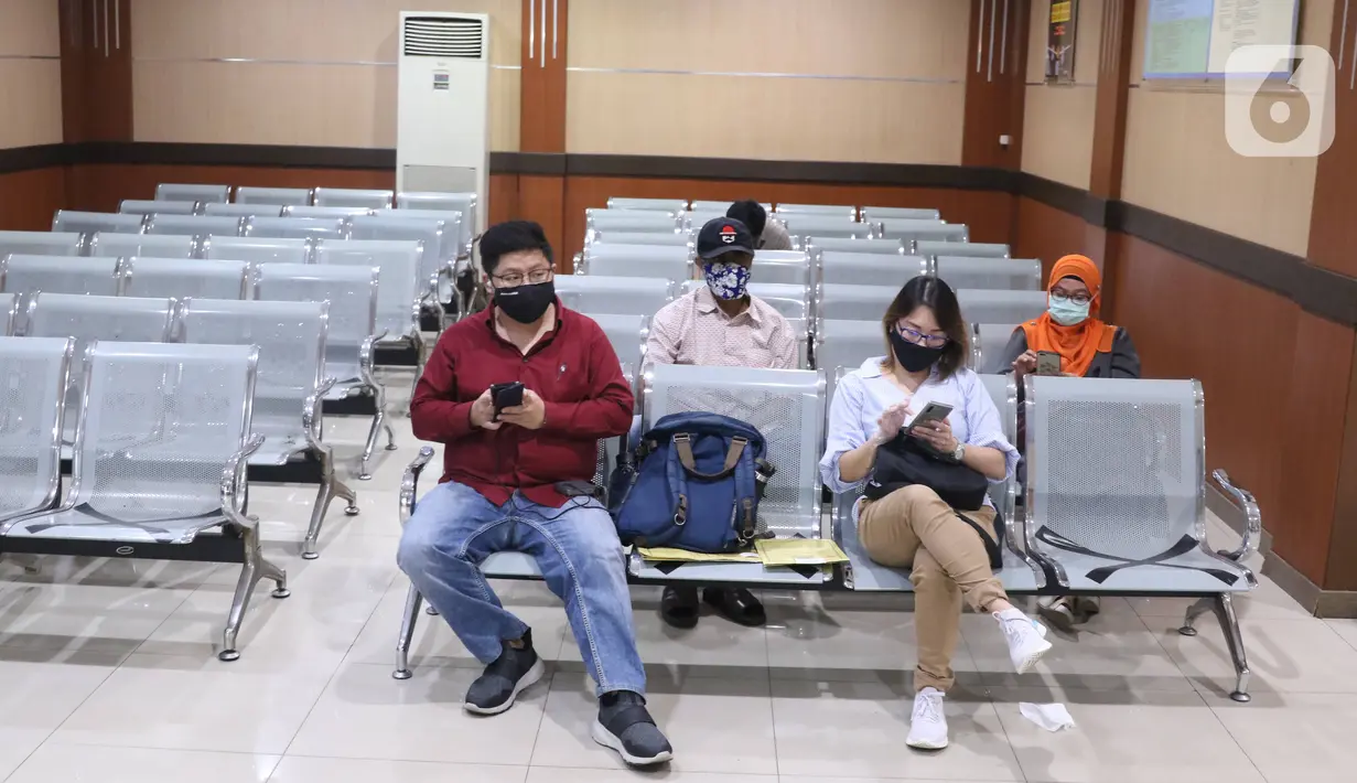Warga menjaga jarak fisik saat menunggu antrean layanan paspor di Kantor Imigrasi Kelas I Non TPI Tangerang, Senin (15/6/2020). Memasuki masa tatanan normal baru, pelayanan keimigrasian untuk warga mulai aktif kembali dengan menerapkan protokol kesehatan. (Liputan6.com/Angga Yuniar)