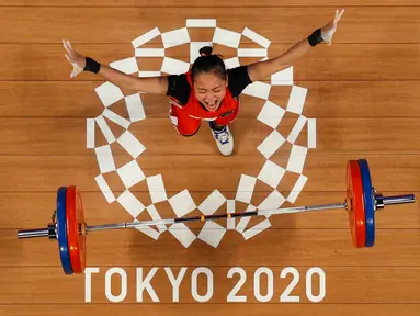 Foto yang diambil dengan kamera robot ini menunjukkan reaksi Windy Cantika Aisah dari Indonesia saat berlaga dalam kompetisi angkat besi 49kg putri pada Olimpiade Tokyo 2020 di Tokyo International Forum, Tokyo pada 24 Juli 2021. (AFP/Pool/Chris Graythen)