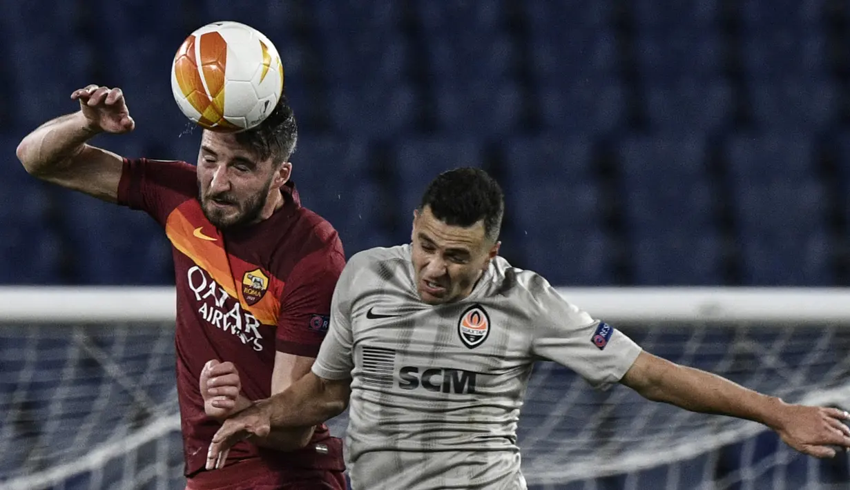 Gelandang AS Roma, Bryan Christante (kiri) berduel udara dengan striker Shakhtar Donetsk, Junior Moraes dalam laga leg pertama babak 16 besar Liga Europa 2020/2021 di Olimpico Stadium, Kamis (11/3/2021). AS Roma menang 3-0 atas Shakhtar Donetsk. (AFP/Filippo Monteforte)