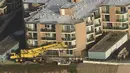 Pekerja merenovasi bangunan apartemen di atas bukit yang terkikis akibat badai El Nino di Pacifica Apartemen di Pacifica, California (26/1). Tiga Kompleks apartemen dikota ini  telah mengalami erosi akibat badai El Nino. (REUTERS/Noah Berger)