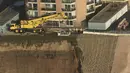 Pekerja merenovasi bangunan apartemen di atas bukit yang terkikis akibat badai El Nino di Pacifica Apartemen di Pacifica, California (26/1). Tiga Kompleks apartemen dikota ini  telah mengalami erosi akibat badai El Nino. (REUTERS/Noah Berger)