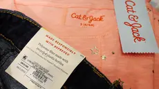 Label pada celana jeans merek Cat & Jack terdapat keterangan bahan dasar pembuatan celana yang dipajang di toko Target, New York, Jumat (14/7). Disebutkan bahwa celana terbuat dari polister daur ulang sebanyak 22 persen  (AP/Mark Lennihan)
