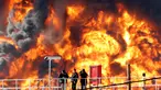 Pekerja mengamati kebakaran besar yang melanda salah satu tangki kilang minyak di Haifa, utara kota Israel, Minggu (25/12). Tidak ada korban jiwa dalam insiden yang masih belum diketahui penyebab kebakaran tersebut. (REUTERS/Baz Ratner)