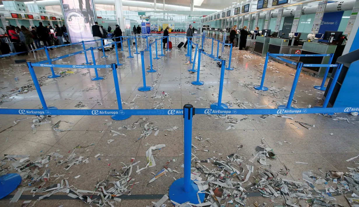 Sampah sobekan kertas berserakan di ruang check in Bandara Barcelona, Spanyol, Kamis (1/12). Para petugas kebersihan bandara tersebut menggelar aksi mogok kerja memprotes pengurangan anggaran sebesar 1,3 juta Euro. (REUTERS/Albert Gea)