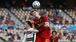 Pemain depan Portugal, Diogo Jota (kiri) melompat untuk menyundul bola saat berebut dengan bek Belgia Thomas Meunier pada babak 16 besar Euro 2020 di Estadio La Cartuja, Sevilla, Senin (28/6/2021) dini hari WIB. Belgia mendepak juara bertahan Portugal berkat kemenangan 1-0. (Julio Munoz/POOL/AFP)