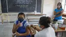 Petugas medis memberikan vaksin COVID-19 kepada seorang siswa di sebuah sekolah di Ahmedabad, Senin (3/1/2022). India mulai memvaksinasi remaja 15-18 tahun saat banyak negara bagian memberlakukan pembatasan ketat untuk menahan lonjakan infeksi yang dipicu oleh varian omicron. (AP Photo/Ajit Solanki)