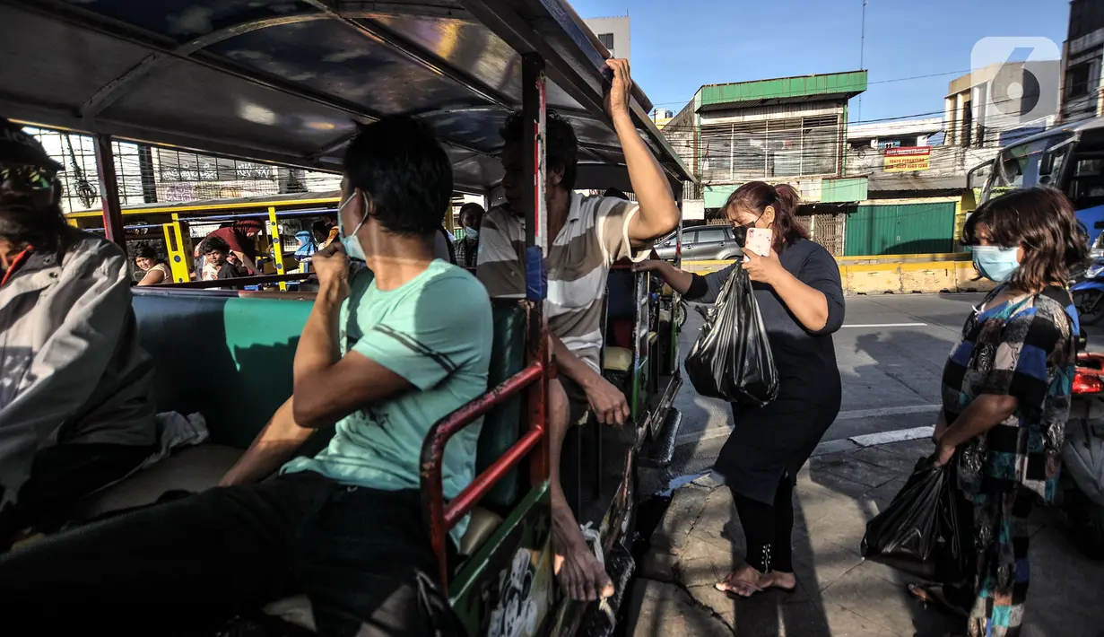 Warga saat menaiki odong-odong di Jalan Inspeksi Ciliwung, Jatinegara, Jakarta Timur, Senin (27/9/2021). Odong-odong di Kampung Pulo ini mulai beroperasi sejak pukul 06.00-18.00 WIB. (merdeka.com/Iqbal S. Nugroho)