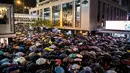 Ribuan pegawai negeri sipil (PNS) mengenakan payung saat mengikuti unjuk rasa menolak RUU Ekstradisi di Hong Kong, Jumat (2/8/2019). Unjuk rasa adalah yang pertama kalinya pegawai pemerintah mempromosikan demonstrasi di Hong Kong. (ANTHONY WALLACE/AFP)
