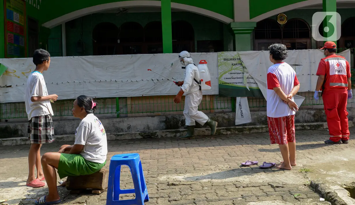 Petugas PMI menyemprotkan cairan disinfektan di Rusun Benhil, Jakarta, Sabtu (4/4/2020). Penyemprotan ini dilakukan untuk pencegahan penyebaran virus COVID-19. (merdeka.com/Imam Buhori)