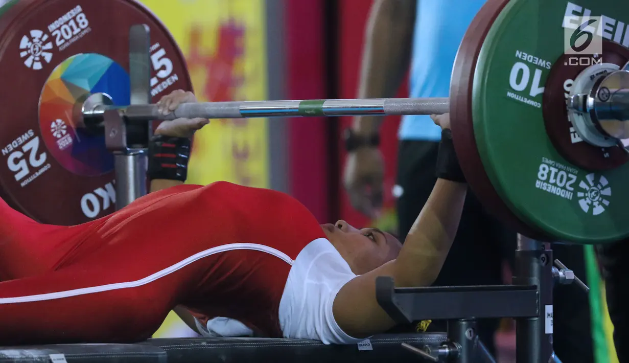 Atlet Para Powerlifting Indonesia, Ni Nengah Widiasih saat melakukan angkatan pada Asian Para Games 2018 di Jakarta, Minggu (7/10). Ni Nengah berhasil menyumbang perak perdana untuk Indonesia di Asian Para Games 2018. (Liputan6.com/Helmi Fithriansyah)