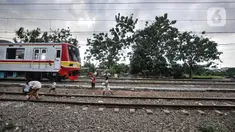 Kereta melintasi anak-anak saat yang bermain di dekat rel di kawasan Bahari Ujung, Tanjung Priok, Jakarta Utara, Selasa (24/5/2022). Minimnya fasilitas dan ruang terbuka hijau di kawasan tersebut menyebabkan anak-anak setempat memilih bermain di sekitar perlintasan kereta api yang dapat membahayakan keselamatan mereka. (merdeka.com/Iqbal S Nugroho)