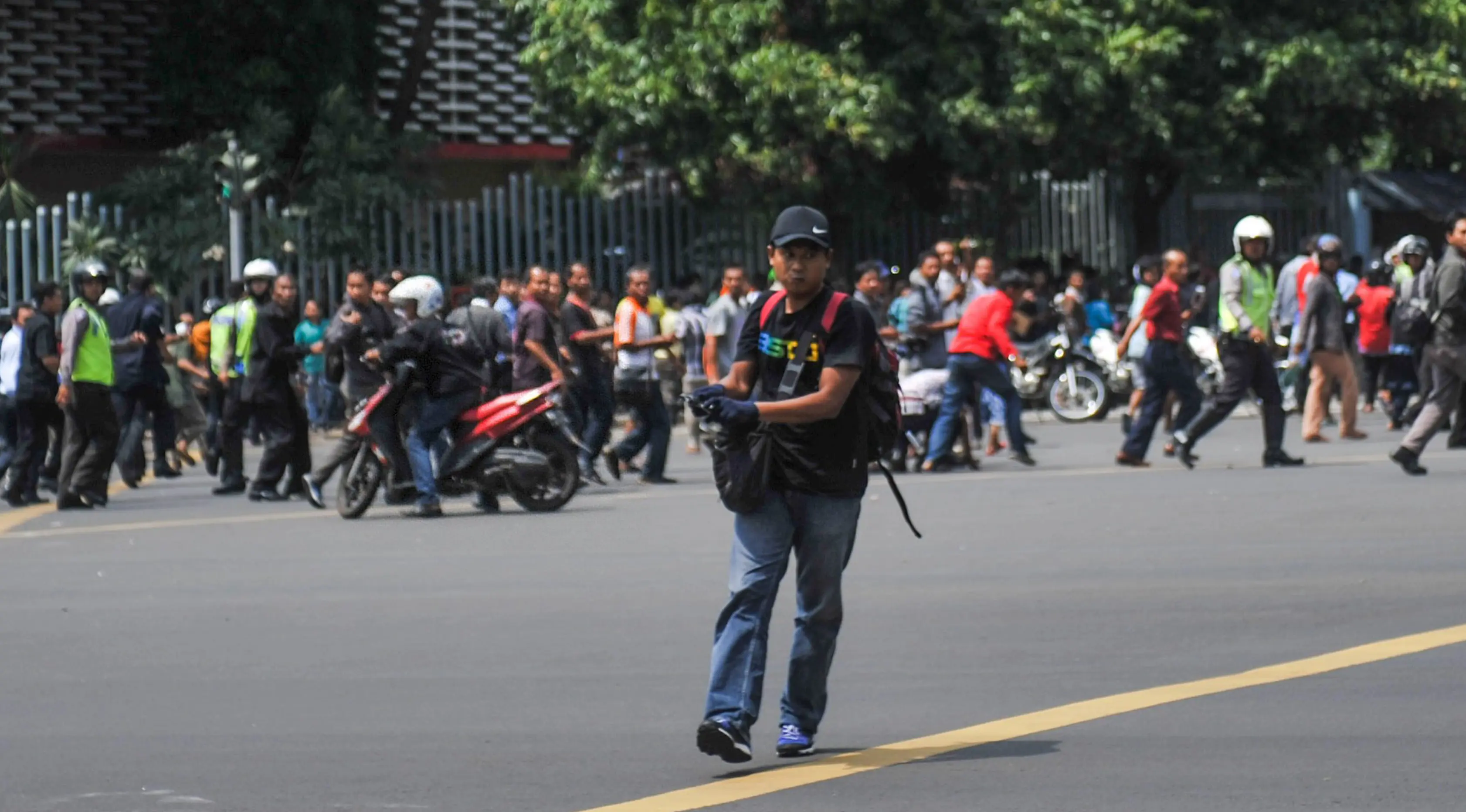 Salah satu pelaku penembakan di persimpangan Sarinah, Jalan MH Thamrin, Jakarta, tertangkap kamera, Kamis (14/1). Pelaku mengeluarkan senjata di tengah kepanikan warga pasca ledakan bom. (REUTERS/Veri Sanovri/Xinhua)