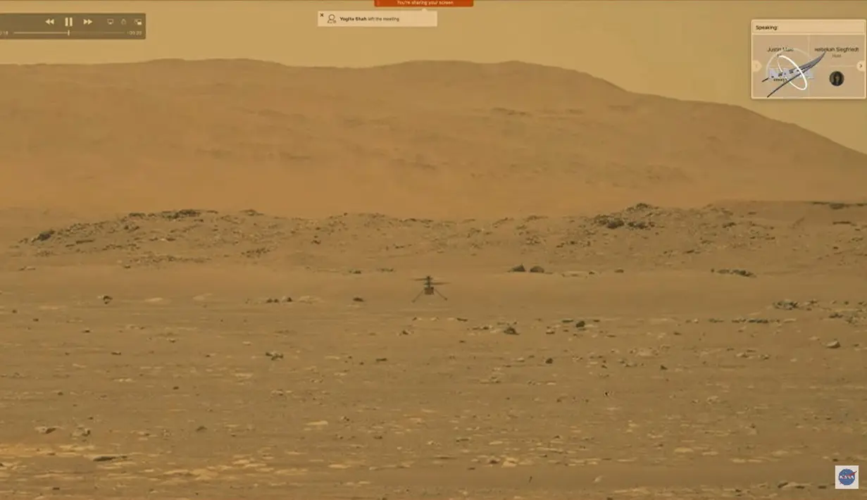Rekaman video yang dibuat dari siaran langsung NASA pada 19 April 2021 ini menunjukkan helikopter Ingenuity terbang di atas permukaan Mars. NASA berhasil menerbangkan helikopter Ingenuity di Mars pada 19 April. (NASA/AFP)