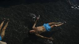 Seorang pria berendam menikmati pemandian air panas alami Sungai Cidaco pada hari musim dingin di desa kecil Arnedillo, Spanyol utara (18/1/2022). Pemandian air panas alami Sungai Cidaco memiliki suhu 35 derajat Celcius (95 derajat Fahrenheit). (AP Photo / Alvaro Barrientos)