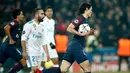 Penyerang PSG Edinson Cavani membawa bola setelah mencetak gol pertama untuk timnya saat menjamu Real Madrid dalam pertandingan Liga Champions leg kedua di stadion Parc des Princes di Paris (6/3). (AP/ Francois Mori)