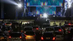 Suasana konser New Live Experience 2020 pada hari kedua di Parkir Barat JIExpo Kemayoran, Jakarta, Minggu (30/8/2020). Konser musik dengan konsep drive-in tersebut digelar dengan menerapkan protokol kesehatan untuk mencegah penyebaran COVID-19. (Liputan6.com/Faizal Fanani)