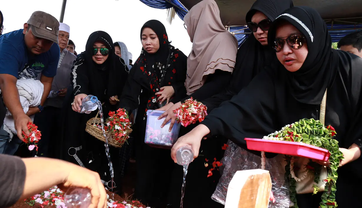Beberapa kali Rina mengusap airmata saat jenazah ayahnya hendak dimasukkan ke liang lahat. Ibu kandung Rina  juga tak kuasa menahan tangis saat suaminya dimasukan ke liang lahat. (Adrian Putra/Bintang.com)