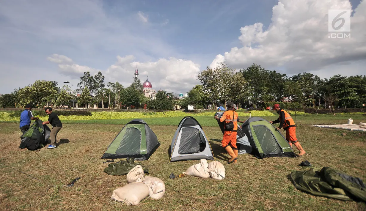 Petugas Penanganan Prasarana dan Sarana Umum (PPSU) mendirikan tenda saat persiapan untuk doa bersama pada malam Tahun Baru di Cipinang Melayu, Jakarta, Minggu (30/12). (Merdeka.com/ Iqbal S. Nugroho)