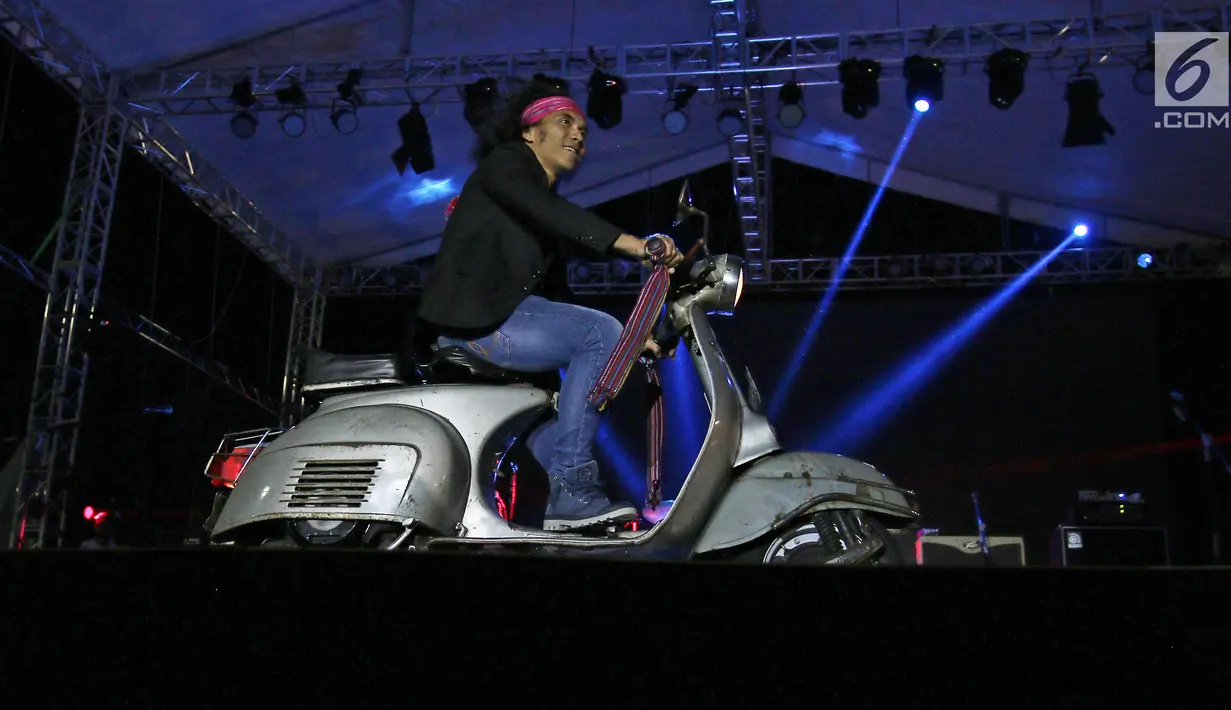 Vokalis band Slank, Kaka mengendarai Vespa di atas panggung konser perayaan HUT ke-34 Slank di JIExpo Kemayoran, Jakarta, Selasa (26/12). Band beraliran rock dan blues tersebut berdiri sejak 26 Desember 1983. (Liputan6.com/Herman Zakharia)