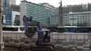 Pekerja dibantu alat berat mengerjakan proyek revitalisasi trotoar di kawasan Bundaran Hotel Indonesia, Jakarta, Selasa (24/9/2019). Pemprov DKI tengah mengebut pembangunan revitalisasi trotoar di sejumlah titik Ibu Kota yang ditargetkan rampung akhir 2019 mendatang. (Liputan6.com/Angga Yuniar)