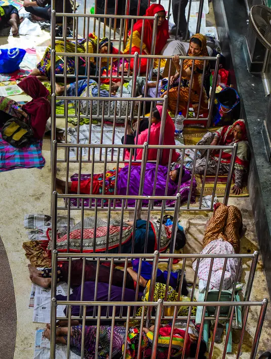 Orang-orang Bangladesh tidur saat mengantre untuk mendapatkan tiket  mudik lebaran di Stasiun Kereta Kamalapur, Dhaka, Kamis (23/5/2019). Sama halnya dengan Indonesia, mudik menjelang Lebaran merupakan salah satu tradisi terbesar tahunan di Bangladesh. (MUNIR UZ ZAMAN/AFP)