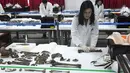 Petugas mengumpulkan sisa kerangka tentara China untuk dimasukkan ke dalam peti mati di osuarium militer, Incheon, Seoul, Senin (26/3). Terdapat 20 kerangka tentara China yang terbunuh selama Perang Korea tahun 1950-1953.  (Jung Yeon-je/Pool Photo via AP)