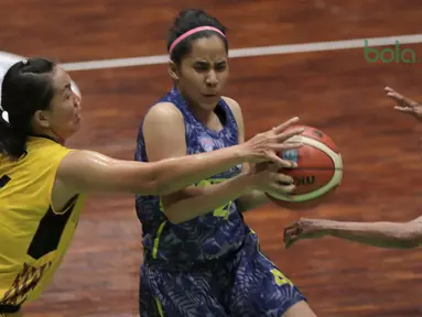 Aksi pemain Merpati Bali, Tania Rasidi melewati adangan dua pemain Tenaga Baru Pontianak pada laga Srikandi Cup 2018 di GOR Lokasari, Jakarta, Rabu (21/3/2018). Merpati Bali menang 61-37. (Bola.com/Nick Hanoatubun)