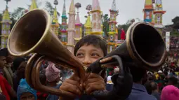 Seorang anak meniup trompet untuk menandai mulainya Festival Behdienkhlam di desa Tuber, India (24/7). Festival Behdienkhlam  adalah salah satu festival paling populer di kawasan Meghalaya. (AP Photo/Anupam Nath)