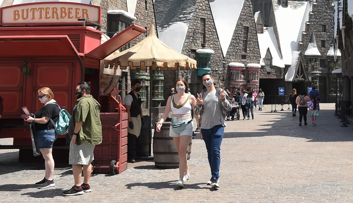 Pemegang tiket masuk musiman menghadiri hari pembukaan Universal Studios di Los Angeles, California, Kamis (15/4/2021). Pemegang tiket tahunan dan musiman dapat kembali ke taman pada tanggal tertentu selama pratinjau khusus Bonus Days yang berlangsung pada 15 April hingga 16 Mei. (LISA O'CONNOR/AFP)