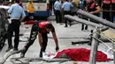 Polisi menutupi tubuh jenazah korban tewas akibat sebuah bus menabrak halte yang penuh penumpang di distrik Dikimevi, Ankara, Turki, Kamis (1/10/2015). 12 orang tewas akibat bus kehilangan kendali karena mengalami rem blong. (AFP PHOTO/ADEM ALTAN)